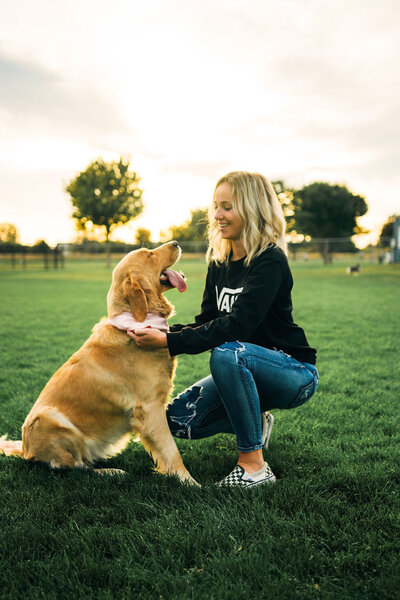 Woman kneeling in front of her dog