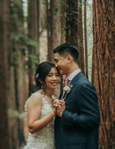 Asian couple standing in front of redwoods
