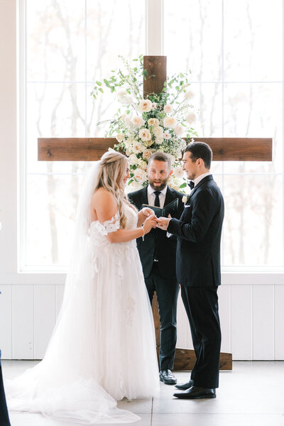 indoor wedding ceremony with bride and groom exchanging rings