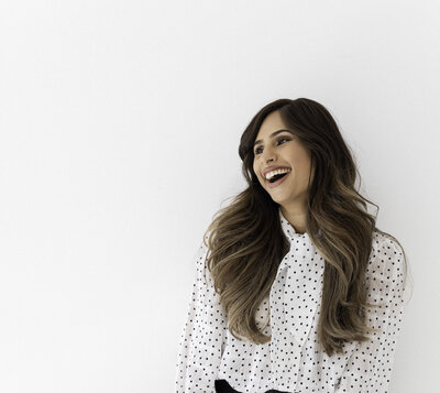 Harj leaning against a wall and laughing