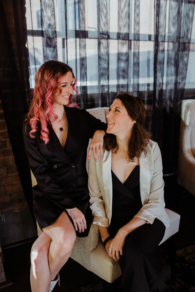 two women sitting on char while smiling at each other