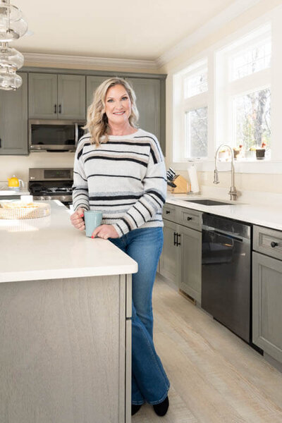 business owner in a kitchen drinking coffee posing for personal branding photographer in baltimore