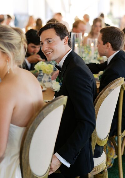 Groom looking at bride during reception speech.