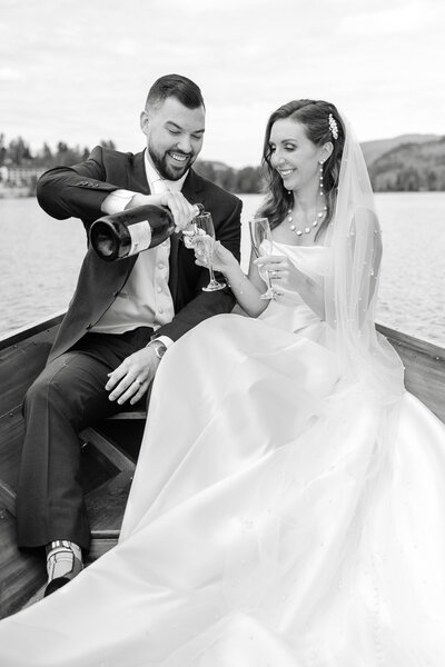 Bride and groom pouring champagne on boat in Upstate New York