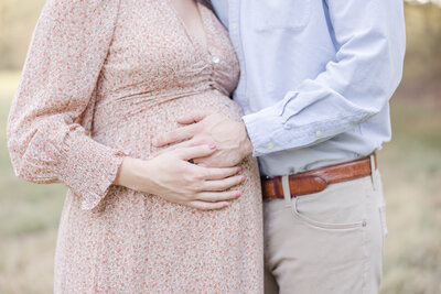 Close up of a couples hands on pregnant mother's belly by Maternity Photographer Greenville SC.