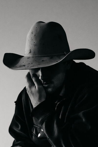 cowboy resting his face on his palm