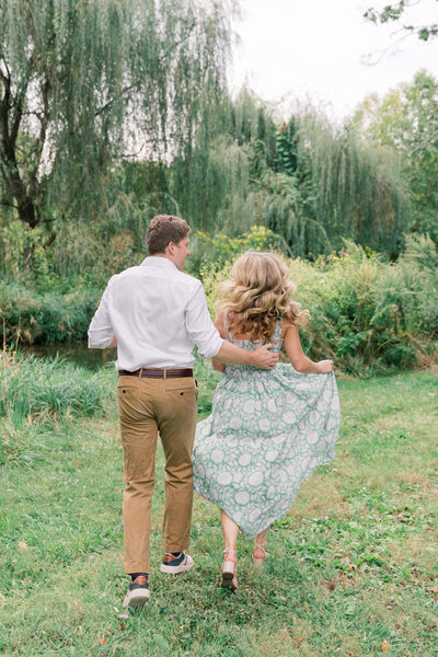 Couple running through a PA garden during engagement session