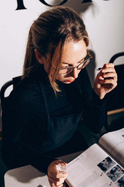 An aesthetics student taking notes during a skincare workshop at Savant Aesthetics Institute.