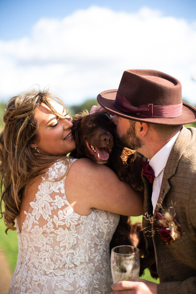 bride and groom kissing their dog