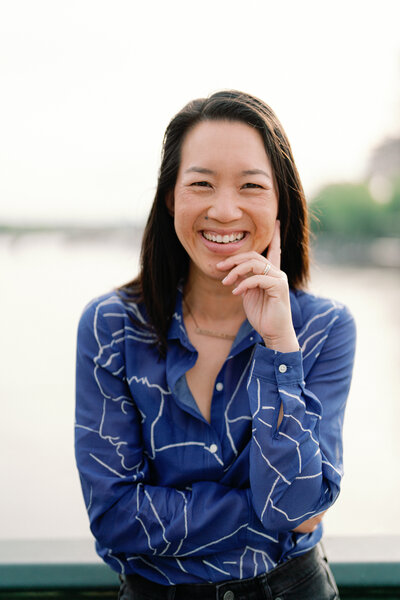 Kim-Trang smiles with the Eiffel Tower faint in the background