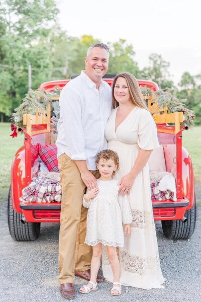 family of 3 standing during a red truck mini session in Northern Virginia