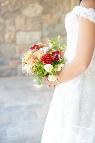 Colorado Springs Bride holding her red, green, and white floral bouquet on her wedding day