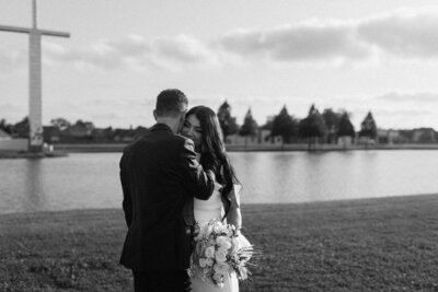 a couple standing close leaning in for a kiss near a beautiful pond in louisiana