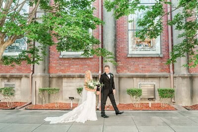 Bride and groom walking on city sidewalk