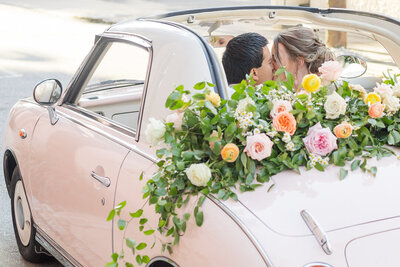 Newlyweds kissing in a getaway car