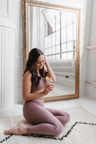 Woman holing a glass of water in a yoga set