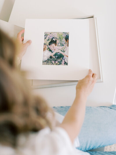 Little Rock photographer's hands removing matted prints from their quality linen print box