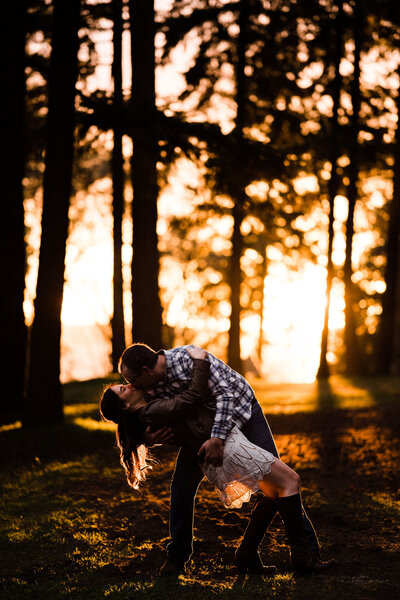 Best spots for engagement pictures in Seattle, a couple kisses at Lincoln Park, with gorgeous sunset captured by wedding photography team
