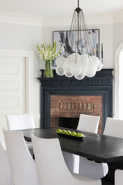 Historic revival dining room in Newton’s Billings Park featuring a modern chandelier, traditional millwork, and a moody color palette