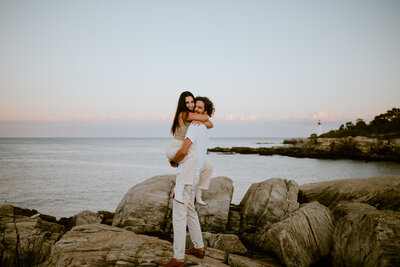 A couple hugs during their engagement session on the coast of Maine near Portland.