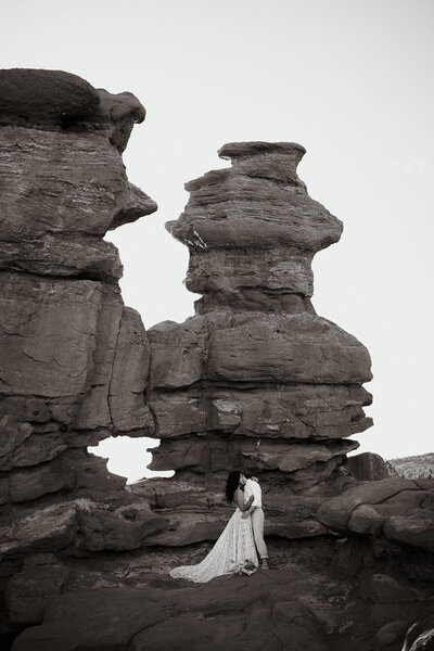 Bride and groom kissing with rock formations in the background