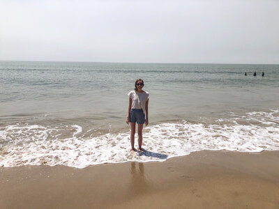 Rachel standing by the ocean in California.
