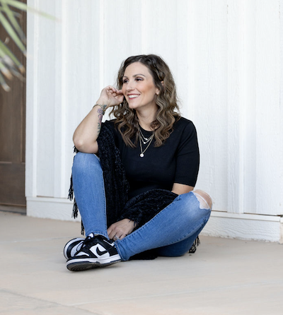 woman sitting on ground wearing black smiling off camera