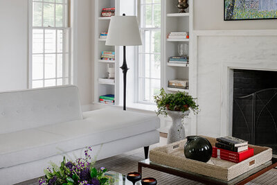 A modern living room design in a historic Hingham home by Hingham interior designers, featuring a modern sofa, mid-century table, and simple white walls.