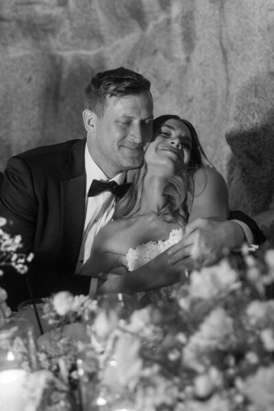 bride and groom hugging at the table during dinner 