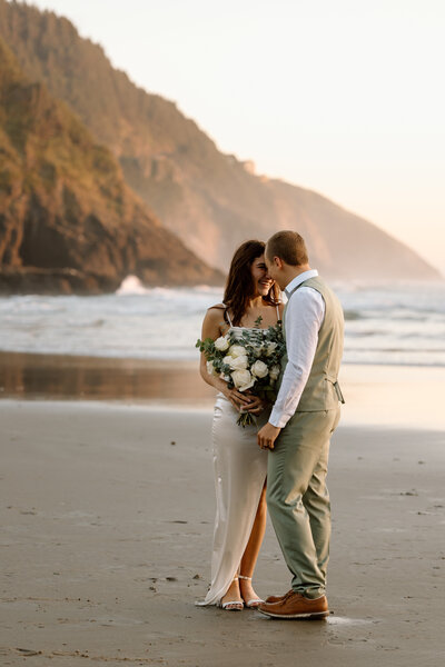 Bride and groom embracing on the Coast.