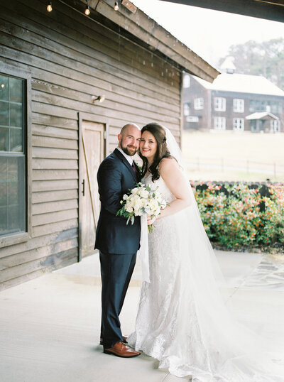 Bride and groom smile for a picture after their first look on a rainy wedding day at the Barn at Shady Lane by Birmingham wedding photographer, Kelsey Dawn Photography