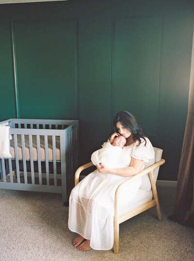 Mother sits green-painted nursery