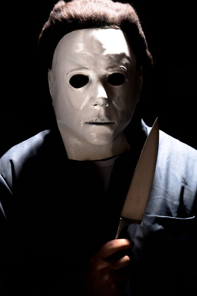 Michael Myers with blacked out eyes holding a knife. Styled similar to Queen Bohemian Rhapsody video.