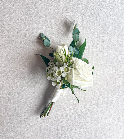 White floral boutonniere with greenery