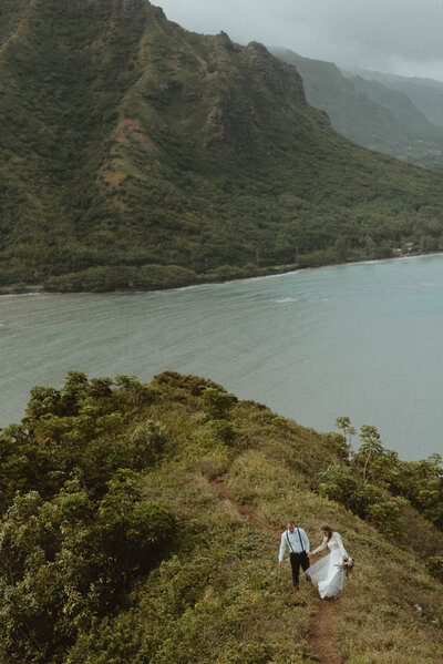 bride and groom hiking along coast