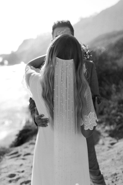 black and white image couple kissing on shoreline