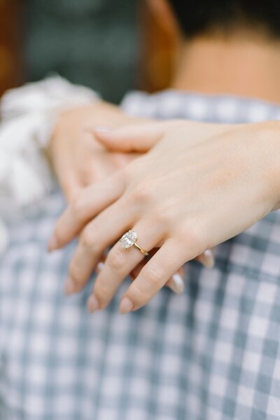 Couple hugging with engagement ring on hand