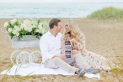 Couple sitting together by baby carriage at Lighthouse Beach