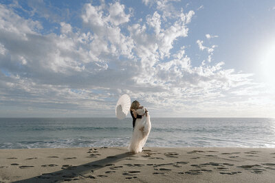 Couple running on beach in wedding attire