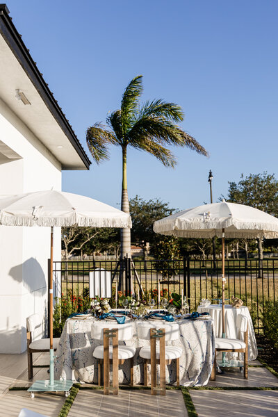 umbrellas over ocaen themed tablescape in modern backyard
