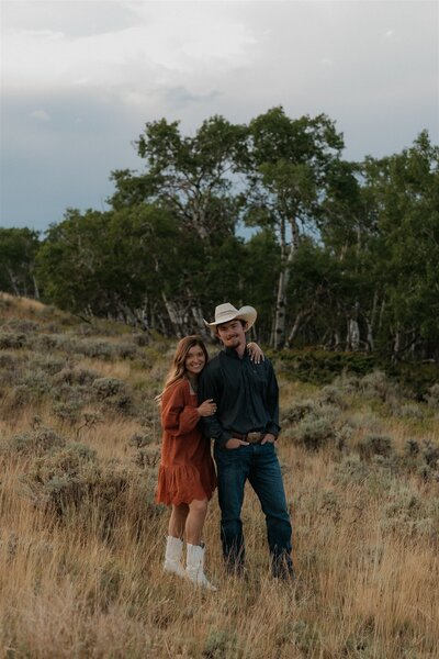 Outdoor portrait of a Wyoming-based photographer, standing in a scenic natural setting with soft lighting and a relaxed pose.