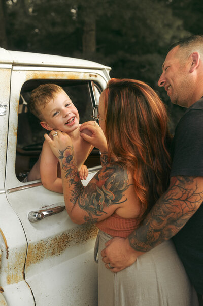 The back of a woman laying on a white bed covered in white sheets. 
