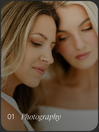 Two woman with their heads resting on one another.