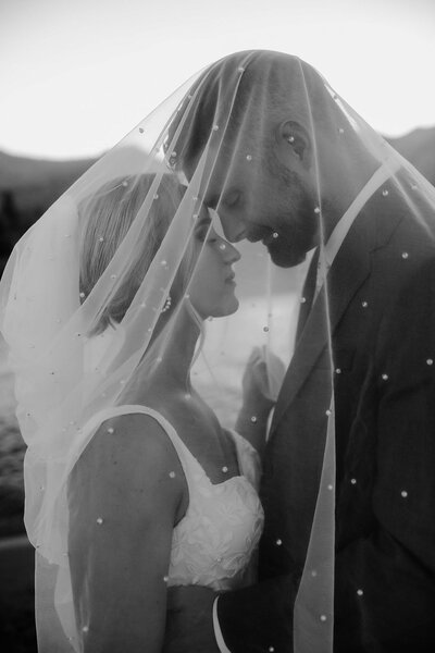 Bride and Groom under pearl veil bridals portraits during sunset on beach in Lake Tahoe