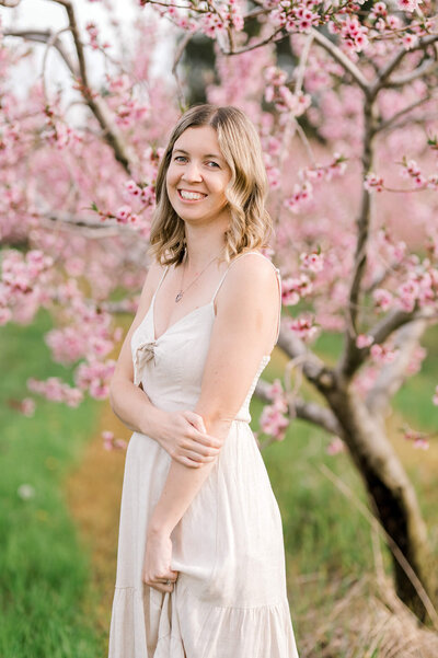 Owner of Kristine Marie Photography in front of cherry blossoms