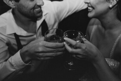 Man and woman cheers their martini glasses and smile