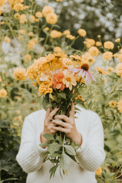 Une femme avec un bouquet de fleurs jaune - Marion gaubert psychologue clinicienne santé perinatal 