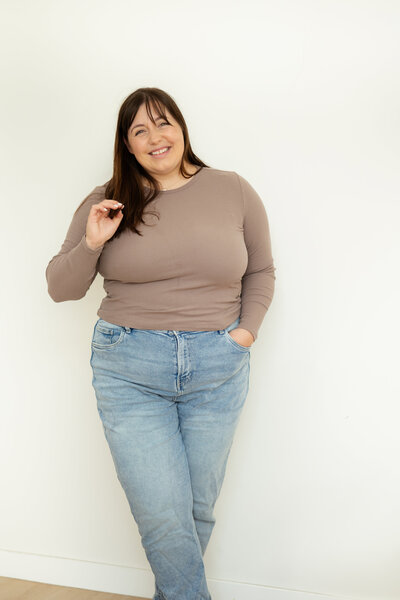Chantal Hewitt smiling and standing in front of a white wall in a brown shirt with blue jeans - Family Autism Support Coach at Chantal Hewitt Coaching3