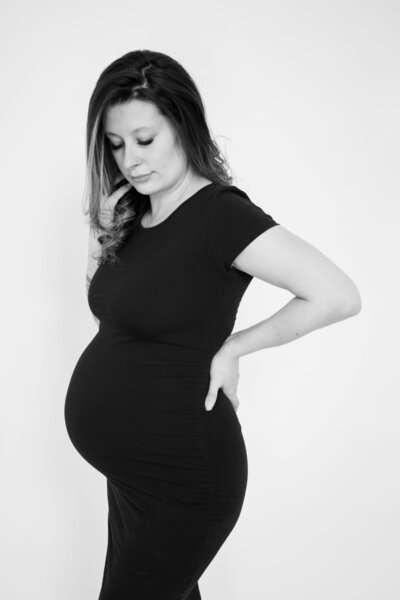 Expecting Mom looking down at pregnant belly | Taken By Maine Photographer