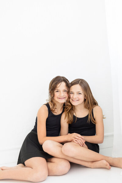 Two sisters looking at each other during family photos with Tiffany Hix Photography in Boise, ID